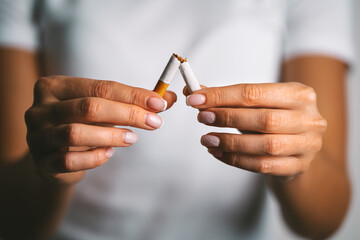 Woman brakes cigarette in hands. Woman refusing tobacco. Stop smoking, quit smoking or no smoking cigarettes - obrazy, fototapety, plakaty