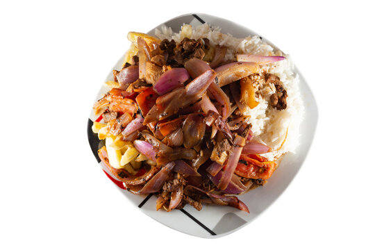 Lomo saltado with beef and Italian tripe with white rice, julienned onions, tomatoes and golden French fries on a white background