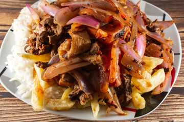 Loin saltado with beef and Italian tripe with white rice, julienned onions and golden French fries