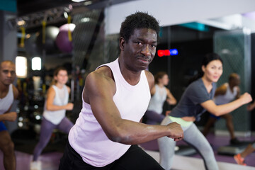 Fototapeta na wymiar Portrait of sporty man doing cardio exercises training with step platform at fitness center