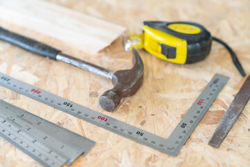 Hammer, Measuring tapes and rasp with builder's supplies.