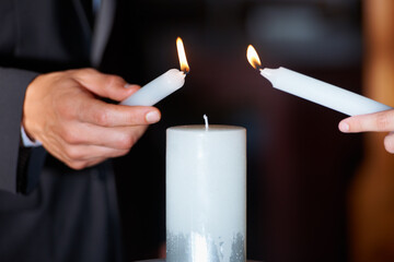 The flame of their love. Closeup shot of a couple lighting candles during their wedding ceremony.