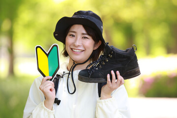 登山靴と初心者マークを持つ女性