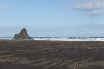 Fototapeta na wymiar A small rocky outcrop at Karekare, a West Coast Beach near Auckland, New Zealand.