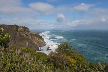 Fototapeta na wymiar A small rocky outcrop at Mercer Bay, West Coast Beach near Auckland, New Zealand.