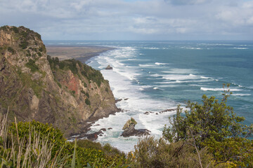 Obraz premium A small rocky outcrop at Mercer Bay, West Coast Beach near Auckland, New Zealand.