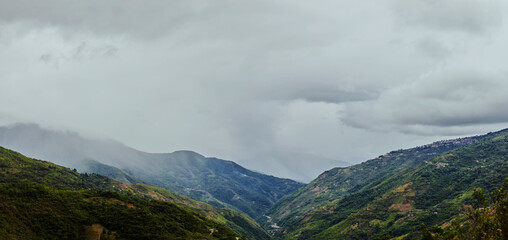 Thick clouds over green mountains