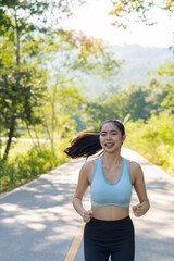 Asian young woman running in the park in the warm sunshine evening health promotion Attractive Asian young woman exercise and smile.