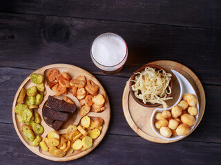 Beer snacks on a wooden table. Beer with pretzels and various snacks.
