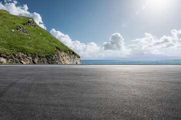 Asphalt road and mountain with sea natural scenery under blue sky