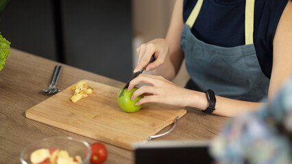 Close-up image, Woman is preparing food in the kitchen, chopping green apple