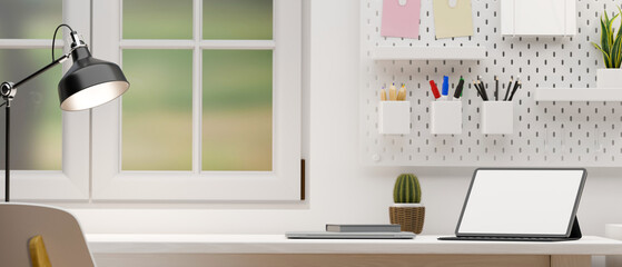Minimal white home office desk workspace near the windows with portable tablet.