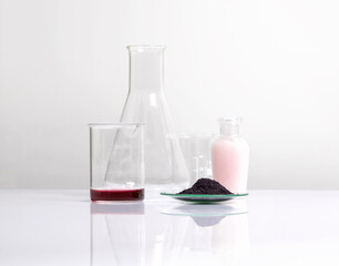 Cosmetic chemicals ingredient on white laboratory table. Potassium Permanganate Liquid, KMnO4, Beauty care cream place next to beaker and erlenmeyer flask.