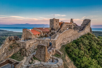 Fototapeta premium Aerial close up view of the upper castle of Szigliget above lake Balaton in Hungary with newly restored walls, towers, palace before sunset