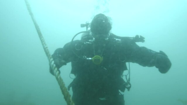 Scuba diver makes safety stop on anchor line on ascent to surface.