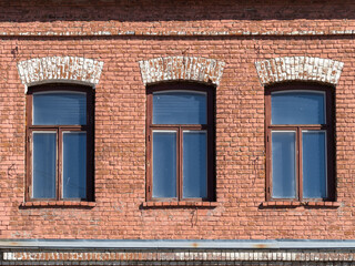 Fototapeta na wymiar Three windows of the old mansion 19 century with brown bricks wall