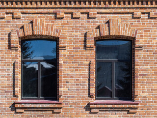 Two windows of the old mansion 19 century with brown bricks wall