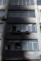 Burnt facade of building. Black walls after fire. Arson concept. Destroyed burned walls after fire extinguished.