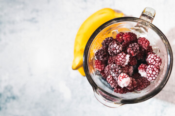 Frozen raspberries inside a blender ready to become a healthy smoothie