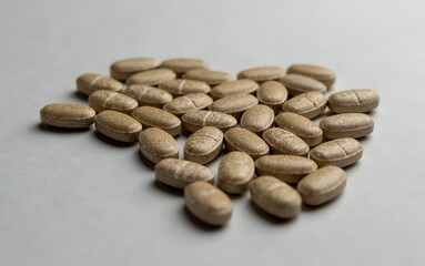 Yellow pills an pill bottle on white background.