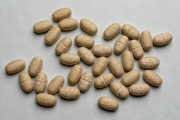 Yellow pills an pill bottle on white background.