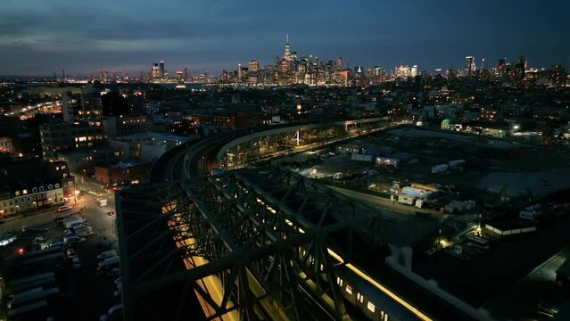 dusk aerial shot following elevated train towards NYC skyline