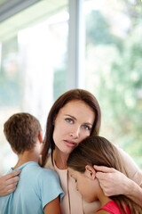 Dealing with a loss in the family. Shot of a loving mother consoling her children at home.