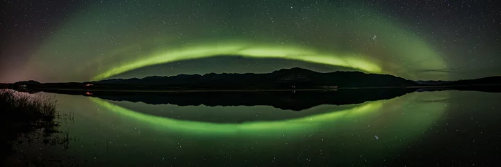 Fotobehang Ghostly northern lights scene in Yukon, Canada during fall with spectacular stars and green aurora borealis band across the northern landscape.  © Scalia Media