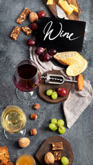 Red wine with appetizers on gray background.