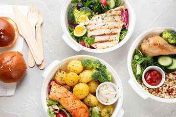 Healthy meal prep in lunch boxes on light background.