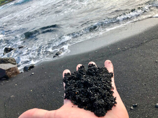 black sand beach with hand