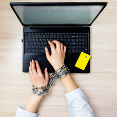 the concept of online shopping addiction.shopaholic. A woman with a metal chain on her hands sits...