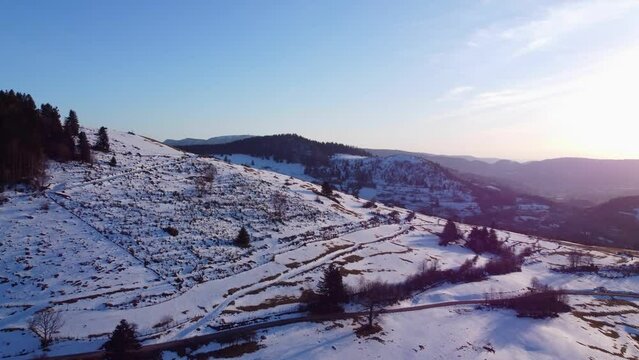 Aerial winter mountain landscape with snow and beautiful sunset light in Le M&eacute;nil Vosges France 4K