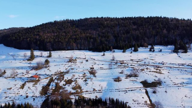Aerial winter mountain landscape with snow forest and beautiful sunset light in Le M&eacute;nil Vosges France 4K