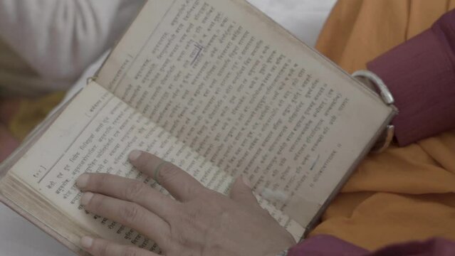 An Indian priest at an Indian traditional Hindu wedding reading book of Mantra . High quality FullHD footage