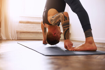 A man practices yoga at home. Male yoga practice