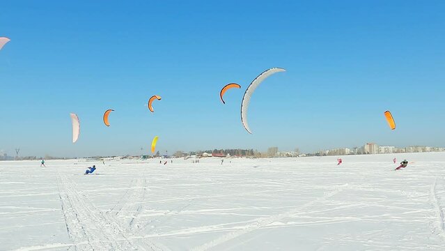 Snowkiting sportsmens in training.
Kitesurfing sport on the ice lake winter. 