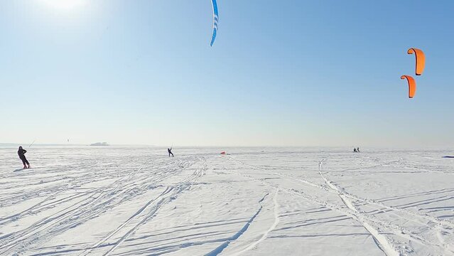 Snowkiting sportsmens in training.
Kitesurfing sport on the ice lake winter. 