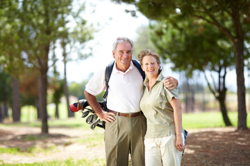 Golf - A sport that brings us closer together. Portrait of a mature and happy couple embracing during a game of golf.