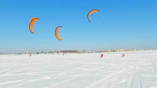 Snowkiting sportsmens in training.
Kitesurfing sport on the ice lake winter. 