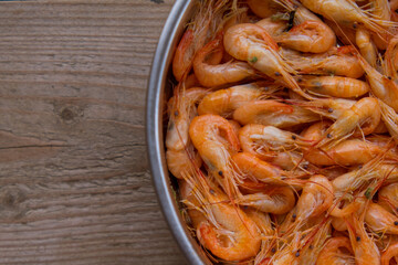 The top view prawns is a seafood. Bring it to boil until cooked to make an orange color look appetizing. In silver tray That was placed on brown wooden block. Copy space