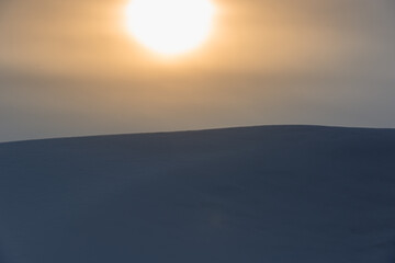 Fototapeta na wymiar The sun and a mountain of snow.
