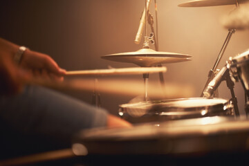 Hes hitting those skins hard. Cropped image of a talented drummer hitting his drum skins hard at a...