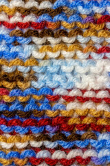 Full frame macro abstract texture background of bright colorful hand-knitted yarn cloth in a simple garter stitch