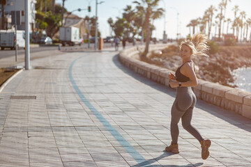 Cheerful and beautiful sporty woman jogging outdoors