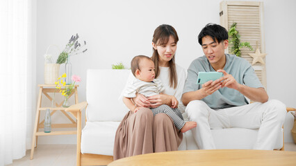 スマートフォンを赤ちゃんに見せる両親