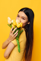 woman with Asian appearance with a bouquet of yellow flowers romance studio model unaltered