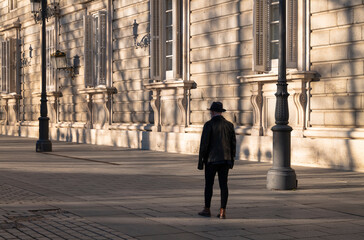 Portrait of adult man in hat and leather jacket against wall on street. Madrid, Spain