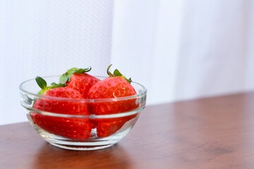 透明なボウルの入れられた美味しそうな真っ赤ないちご