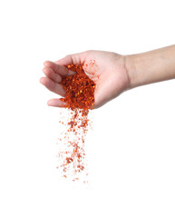 Hand sprinkling cayenne pepper on white background